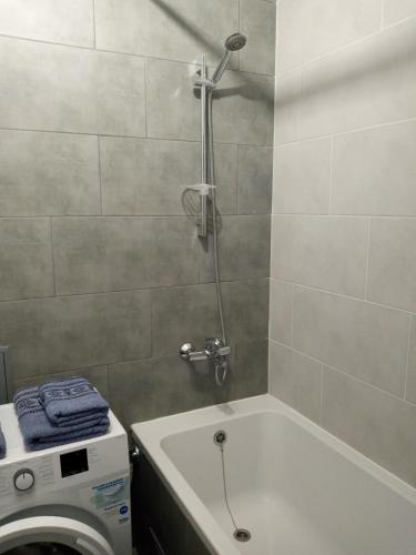 y baño con bañera y lavadora. en Luxury Central Apartment en Úzhgorod
