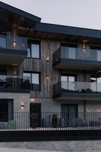 an apartment building with black balconies and tables at GOING TRIPLE A apartments WEST in Going