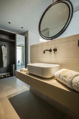 a bathroom with a sink and a mirror on a counter at Royalty Hotel Athens in Athens