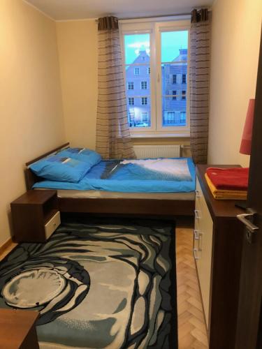 niewielka sypialnia z łóżkiem i oknem w obiekcie Apartament w Sercu Starego Miasta w Olsztynie
