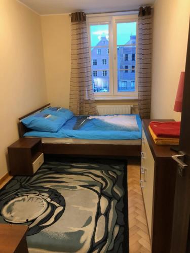 um pequeno quarto com uma cama e uma janela em Apartament w Sercu Starego Miasta em Olsztyn