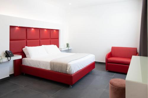 a bedroom with a red bed and a red chair at GRAND HOTEL SERAPIDE in Pozzuoli