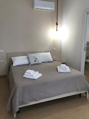 a bedroom with a bed with towels on it at Le Quattro Perle in Terrasini