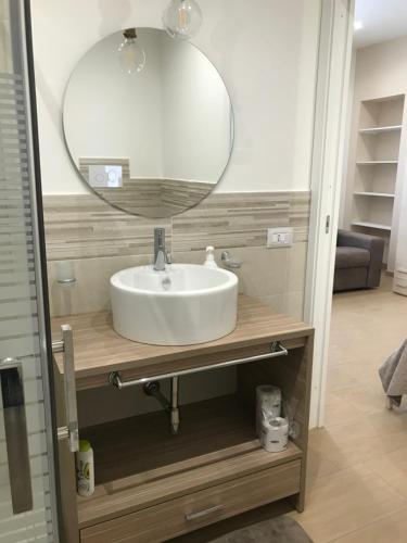 een wastafel in de badkamer met een grote spiegel erboven bij Le Quattro Perle in Terrasini