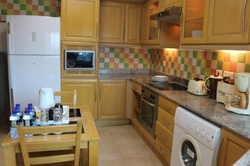 a kitchen with a white refrigerator and a table at City Center Hotel in Manama