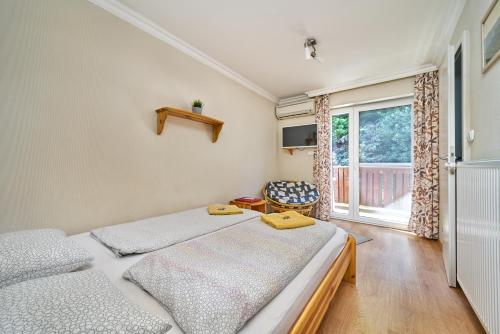 a bedroom with two beds and a window at Villa Harmónia Panzió in Visegrád