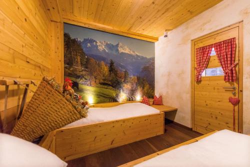 a bedroom with a mountain mural on the wall at DAS ROYAL in Obereggen in Obereggen