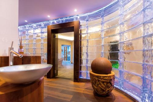ein Badezimmer mit einem Spülbecken und einer Glaswand in der Unterkunft DAS ROYAL in Obereggen in Obereggen