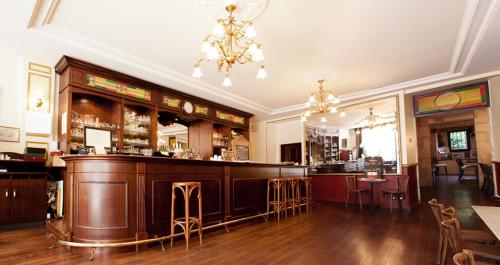 a bar in a restaurant with a bar counter at Hostellerie du Coq d'Or in Jonzac