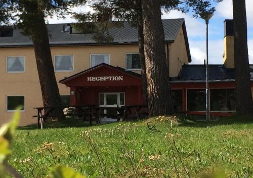 a building with a picnic table in the grass at Hotell Bruksvallsliden in Bruksvallarna
