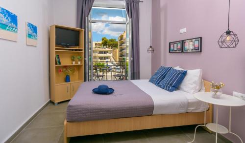 Schlafzimmer mit einem Bett, einem TV und einem Fenster in der Unterkunft Central Studio in Agios Nikolaos