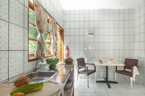 a kitchen with a sink and a table at Tannette Villa in La Digue