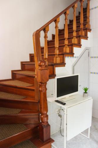 a computer sitting on a desk under a staircase at Ascensor House in Nazaré