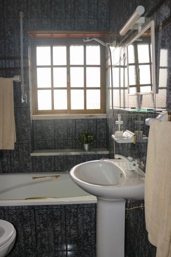 a bathroom with a sink and a bath tub at Ascensor House in Nazaré