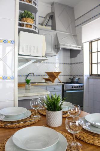 a kitchen with a table with plates and wine glasses at Ascensor House in Nazaré