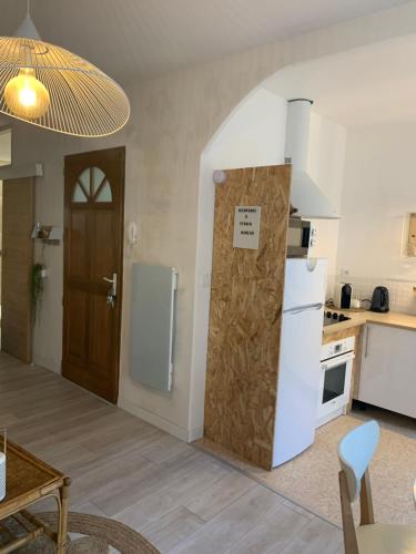 une cuisine avec un réfrigérateur blanc et une table dans l'établissement Margoo douceur de vivre au Panier SooHome, à Marseille