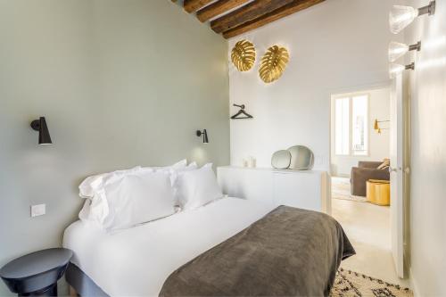 - une chambre blanche avec un lit et un salon dans l'établissement Habitat Parisien - 2BR-2BA - Marais - Hôtel de Ville, à Paris