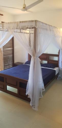 a bed with a canopy in a room at Lotus Villa Kandy in Peradeniya