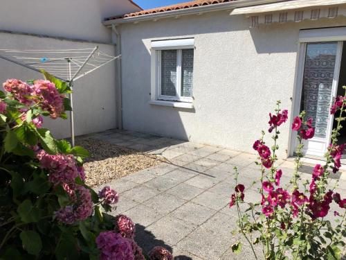 a house with pink flowers in front of it at St Georges de Didonne, Maison bien équipée au calme in Saint-Georges-de-Didonne