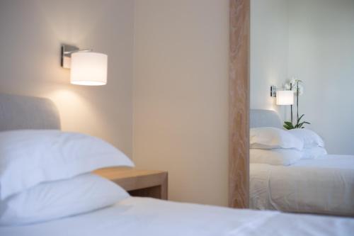 a bedroom with two beds and a mirror at Porto Naxos in Naxos Chora