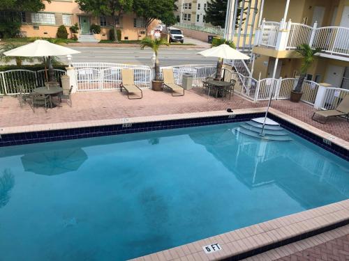a swimming pool in a hotel with chairs and umbrellas at Beach Place Hotel in Miami Beach