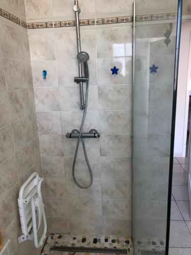 une salle de bain avec une douche avec une porte vitrée dans l'établissement St Georges de Didonne, Maison bien équipée au calme, à Saint-Georges-de-Didonne