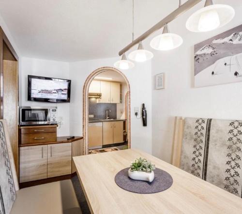 ein Wohnzimmer mit einem Tisch und einer Küche in der Unterkunft Altes Holzhaus in Sölden