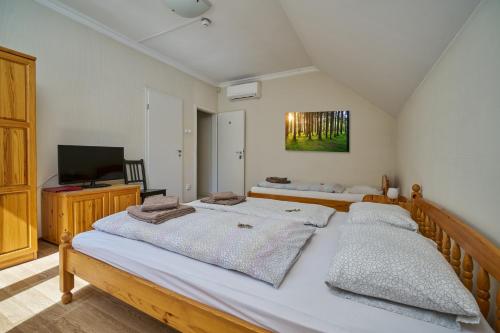 A bed or beds in a room at Villa Harmónia Panzió