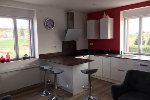 une cuisine avec un comptoir et des tabourets dans une pièce dans l'établissement Gîte de chenieux, à Saint-Victor-sur-Loire