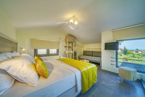 ein Schlafzimmer mit einem großen Bett und einem großen Fenster in der Unterkunft Miroes Suites in Nikiti