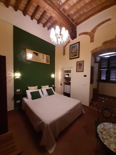 1 dormitorio con cama y pared verde en Locazione Turistica Totti, en San Gimignano