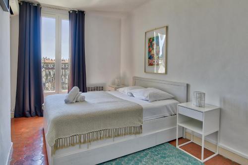 a white bedroom with a bed and a window at NOCNOC - Le Republique in Marseille