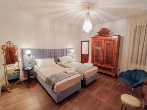 1 dormitorio grande con 2 camas y 1 silla en Dimora Decò, en Lugo