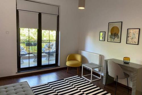 a living room with a desk and a chair at La Tuya Deluxe Villa in Iaşi