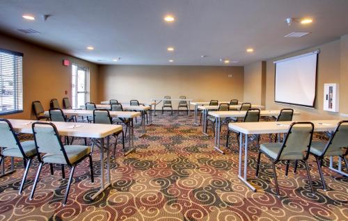 a conference room with tables and chairs and a whiteboard at Cobblestone Inn & Suites - Rugby in Rugby