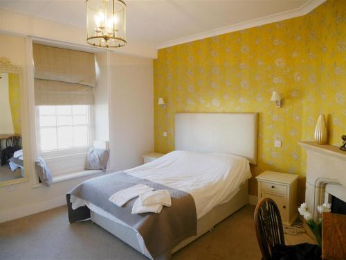 a bedroom with a bed and a fireplace and a window at The Saracens Head Hotel in Highworth