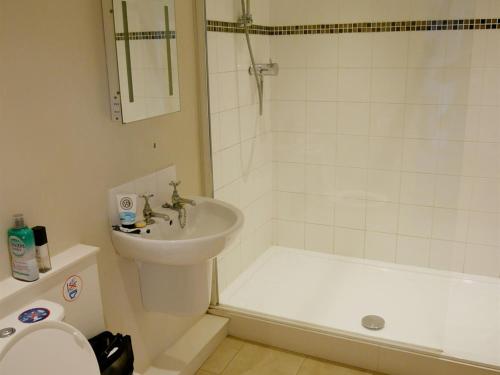 a bathroom with a sink and a toilet and a tub at The Saracens Head Hotel in Highworth