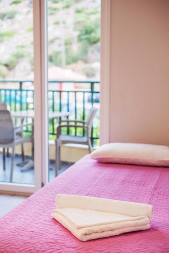 a purple bed with two towels on top of it at Stefania Studios by Estia in Stalís