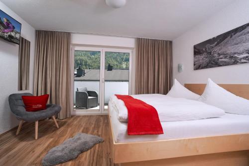 une chambre d'hôtel avec un lit, une chaise et une fenêtre dans l'établissement Apart Alessandro, à Längenfeld