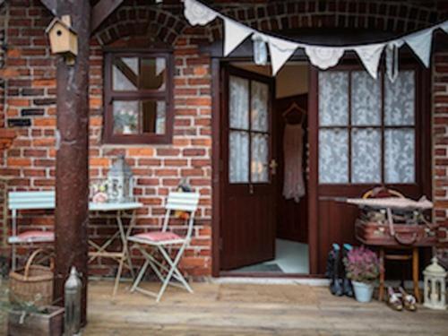 a brick house with a door and a table and chairs at The Shepherd's Purse in Whitby