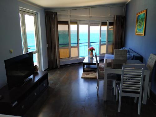 ein Wohnzimmer mit einem TV, einem Tisch und Stühlen in der Unterkunft Apartmani Orange Dreams in Sutomore