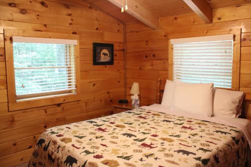 a bedroom with a bed in a log cabin at Country Road Cabins in Hico