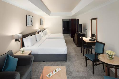a hotel room with a bed and a living room at Anwar Al Madinah Mövenpick in Al Madinah