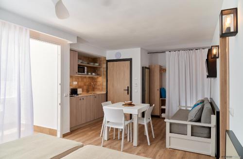 a living room with a table and a kitchen at Apartamentos Sabina Playa in La Savina