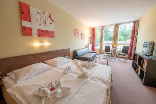 Un dormitorio con una gran cama blanca con flores. en Parkhotel Eisenstadt, en Eisenstadt