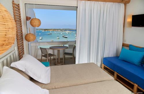 a bedroom with a bed and a view of the ocean at Apartamentos Sabina Playa in La Savina