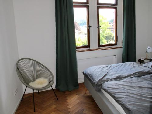 a bedroom with a bed and a chair and a window at Altes Forstamt in Gernsbach