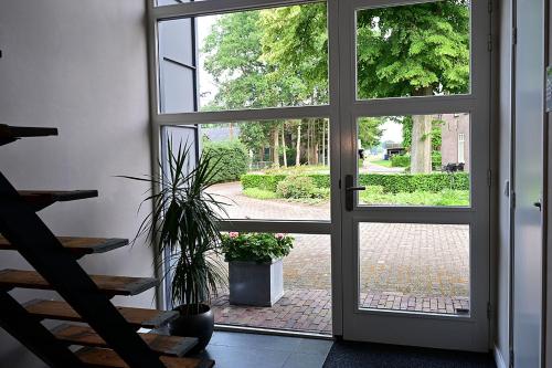 an open door to a patio with a potted plant at De Lakenvelder B&B Eersel in Eersel