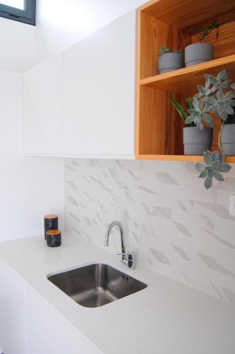 a kitchen counter with a sink and a cabinet at Verde'Água Family Home in Mosteiros