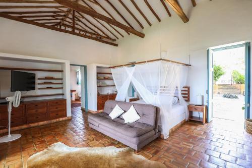 a bedroom with a bed and a couch and a tv at Casa Barichara Boutique in Barichara